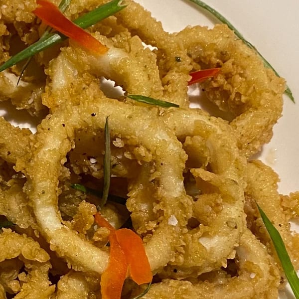 Crispy fried calamari rings, garnished with red pepper strips and green herbs, from Trelawny Fusion Kitchen.
